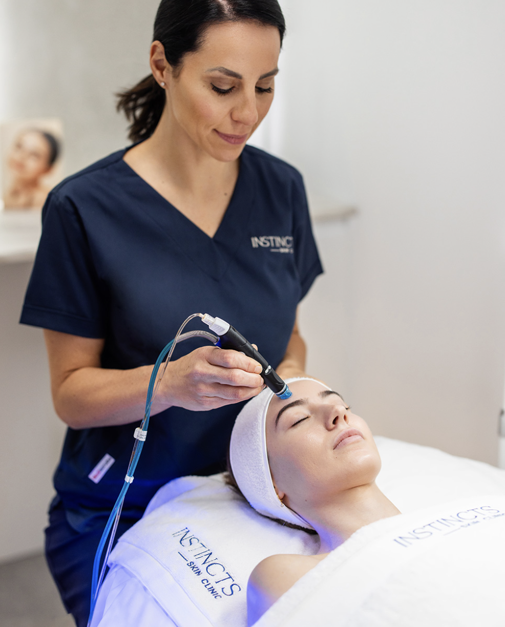 An Instincts dermal therapist performing an LED skin treatment in the Bella Vista clinic